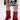 A person wearing a black and white floral skirt stands in shiny AZALEA WANG SILVA RED LACE UP STILETTO BOOTIES featuring pointed toes, thin sculptural stiletto heels, and a glossy faux patent leather finish.