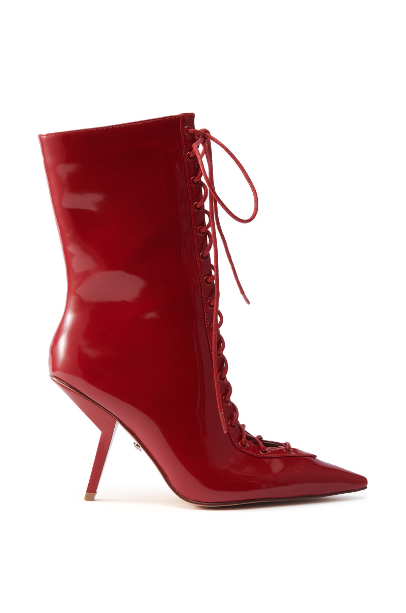 The AZALEA WANG SILVA RED LACE UP STILETTO BOOTIE features patent leather, a pointed toe, side laces, and a high sculpted stiletto heel for a bold statement look.