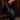 A close-up of a person wearing the AZALEA WANG SINISTER BLACK WESTERN CHUNKY BOOT, featuring metallic chains, standing indoors on a wooden floor against dark wood paneling.