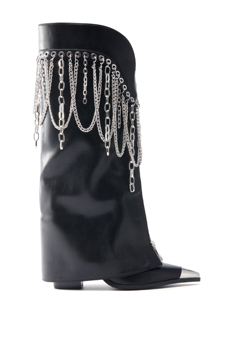 The AZALEA WANG SINISTER BLACK WESTERN CHUNKY BOOT is a black faux leather boot with a metallic chain fringe on one side and a metallic silver pointed toe, merging edgy and elegant styles.