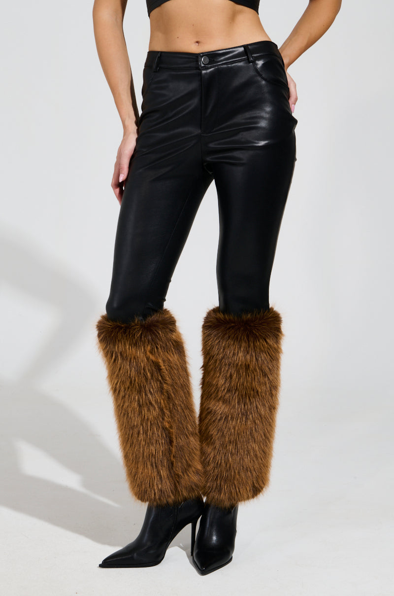 The person wears SIREN FUR TRIM FAUX LEATHER PANTS along with brown faux fur leg warmers and black pointed-toe high-heeled shoes. The image focuses on their lower body against a plain background.