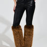 The person wears SIREN FUR TRIM FAUX LEATHER PANTS along with brown faux fur leg warmers and black pointed-toe high-heeled shoes. The image focuses on their lower body against a plain background.