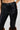 A close-up of a person wearing SIREN FUR TRIM FAUX LEATHER PANTS with front pockets. The figure-flattering design includes a button and zipper closure, and the lower legs are adorned with brown fur for a distinctive style accent.