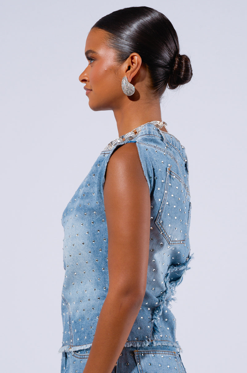 A woman with a sleek, low bun hairstyle faces to the side, wearing sparkly earrings and the DENIM DIVA OFF SHOULDER TOP adorned with small AB rhinestone embellishments. The background is light gray.