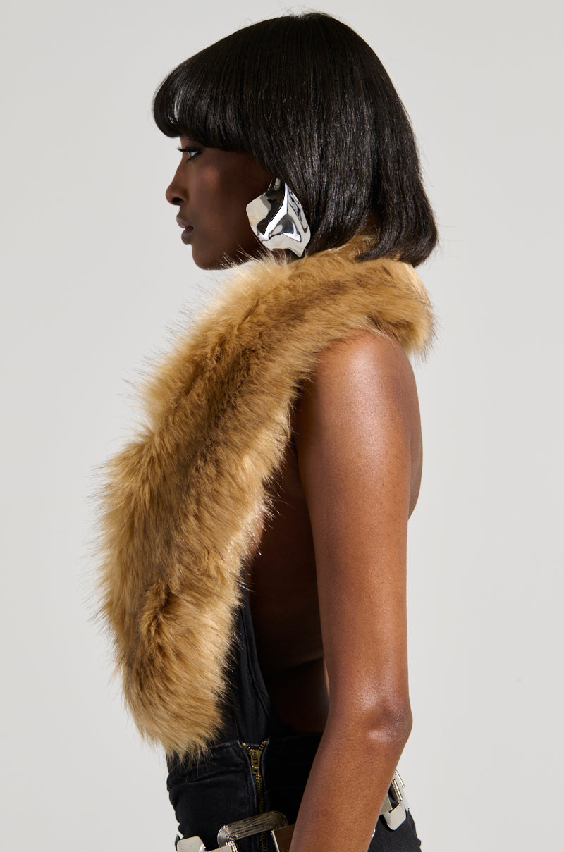 A person with shoulder-length black hair wears a large silver earpiece and a brown faux fur scarf draped over one shoulder. They are dressed in the FEELS GOOD BODYSUIT against a plain background.
