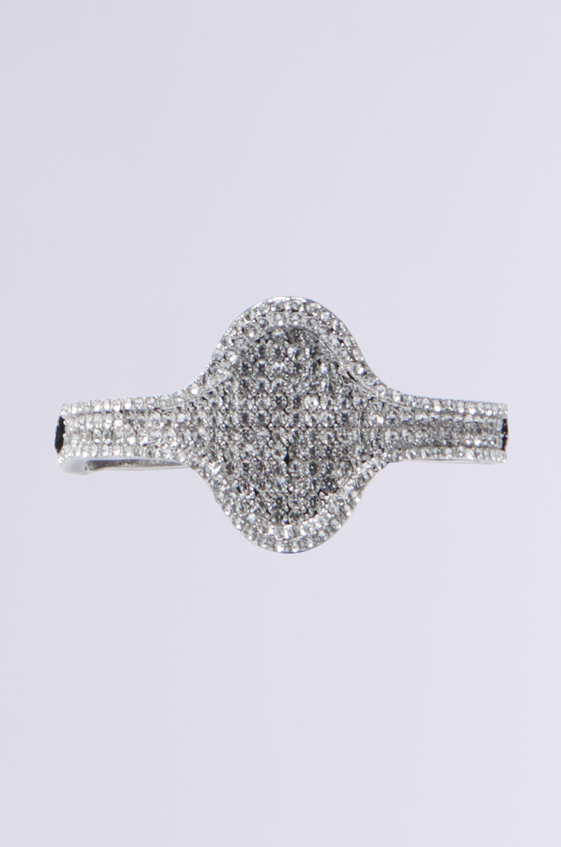 A glittering, diamond-encrusted bracelet featuring rhinestone detailing and an oval centerpiece is displayed against a plain white background.