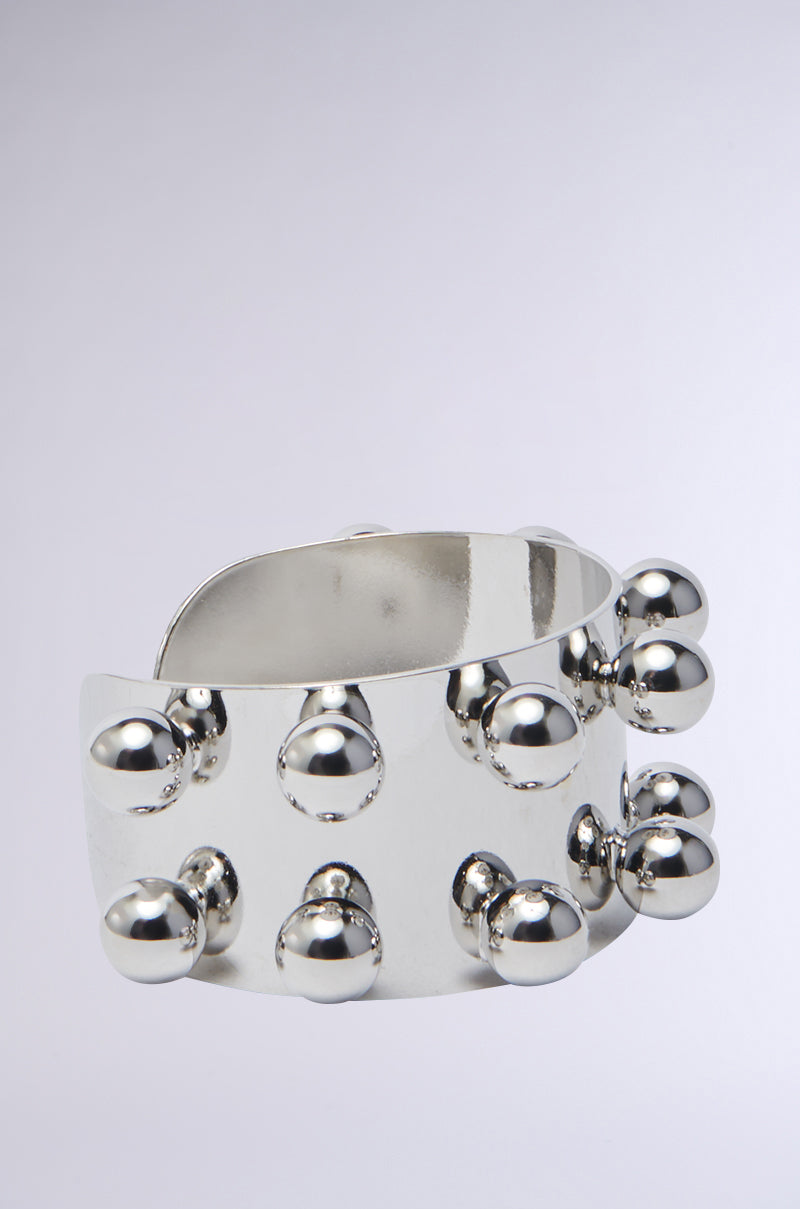 The WHAT A STUD SILVER CUFF is a bold, shiny faux silver bracelet featuring multiple raised, round studs evenly spaced across its wide surface—an edgy accessory perfect for standout style. 2