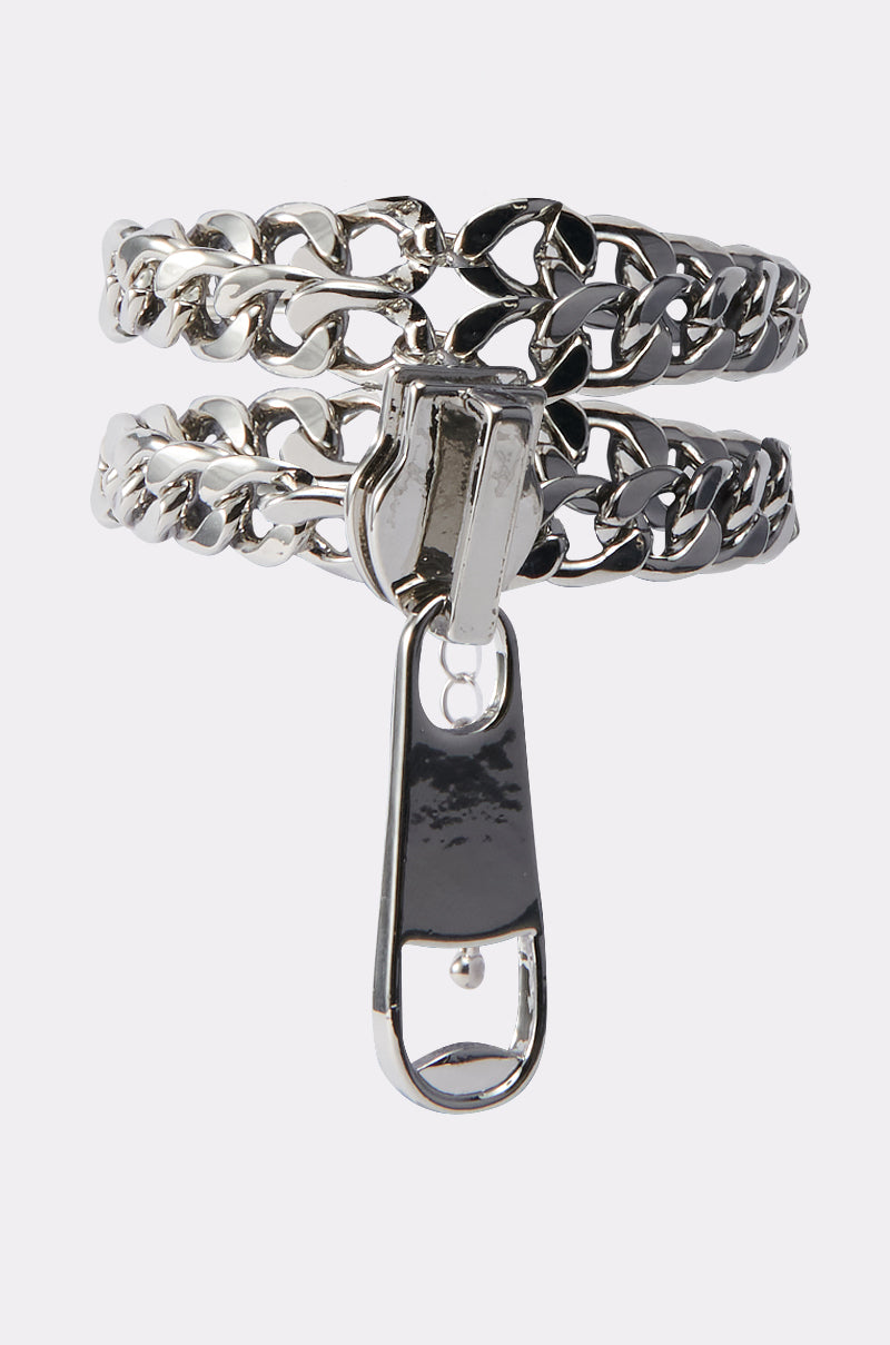 The ZIP IT UP BRACELET features chunky silver curb chains as dual bands connected by a central zipper pull, creating a unique and edgy accessory.