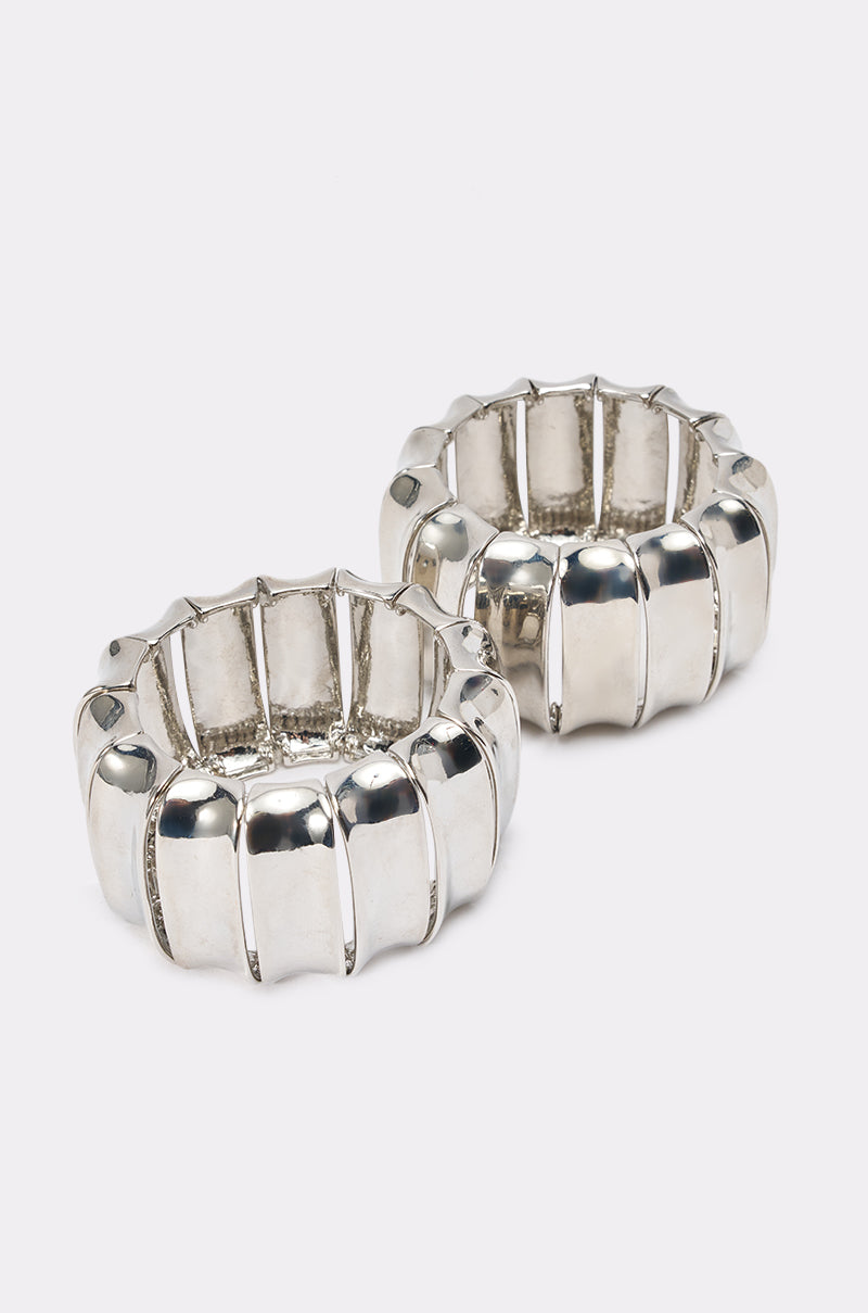 The ULTIMATE CUFF SET features two chunky, silver-toned ribbed bracelet cuffs with a segmented, rounded design, displayed side by side on a plain white background. 0