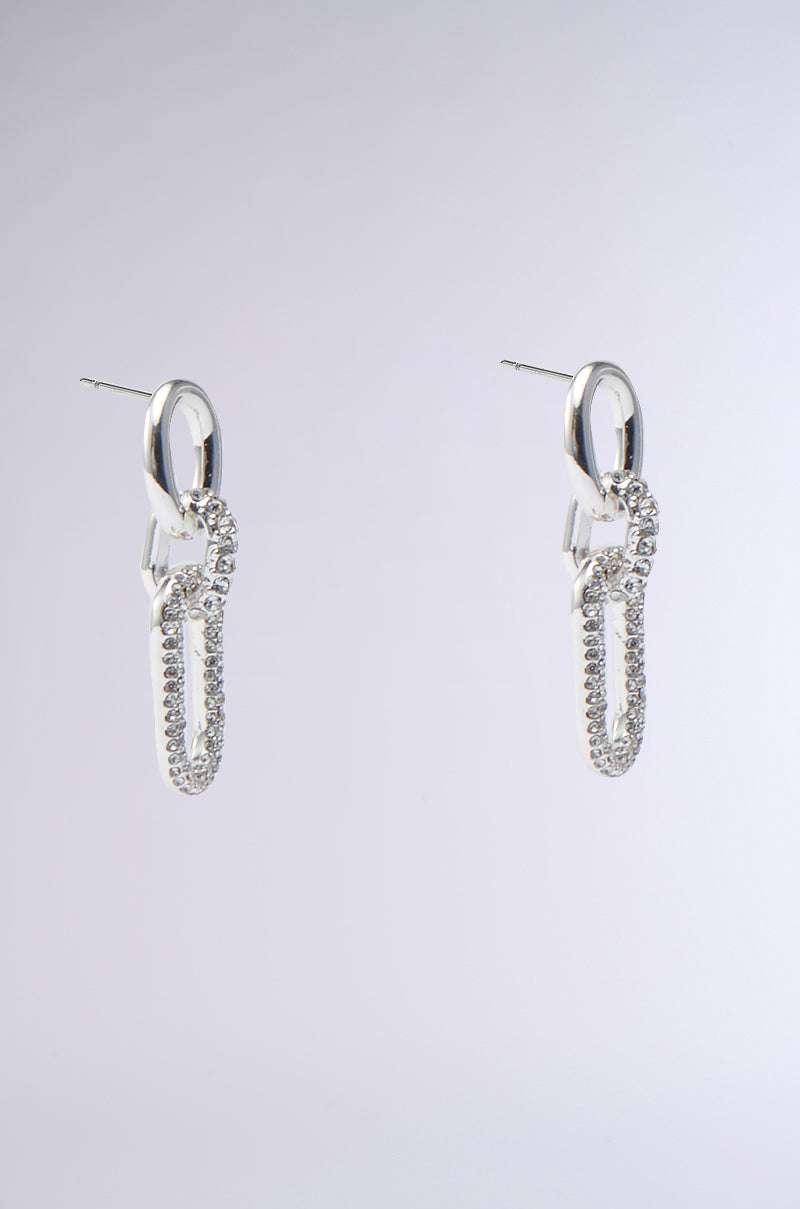 The modern chain-link PAVE DANGLE EARRING from the AKIRA Label collection features cubic zirconia stones on each link, exuding a sleek and elegant look against a light grey background. 2