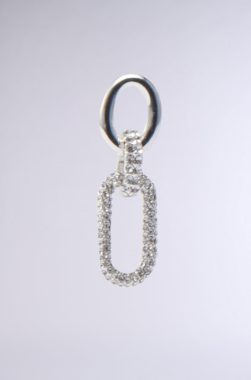 A PAVE DANGLE EARRING adorned with cubic zirconia stones hangs against a soft gray background. The elongated oval shape is intricately detailed, offering a luxurious appearance reminiscent of an AKIRA Label masterpiece. 3