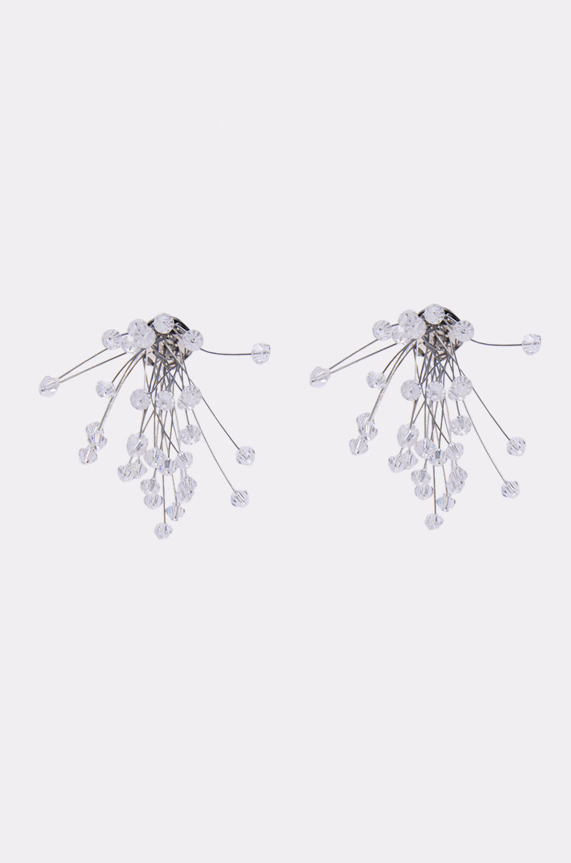 The IN PARIS EARRING features silver statement earrings with multiple thin stems ending in clear beads, arranged in a splayed and delicate, abstract starburst floral design against a plain white background. 1