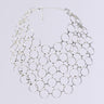 The RUNNING IN CIRCLES NECKLACE exhibits a stunning silver design with o-ring hardware, displaying interconnected circular links in a broad, net-like pattern. This eye-catching accessory includes a clasp and an adjustable chain, elegantly presented against a simple white backdrop.