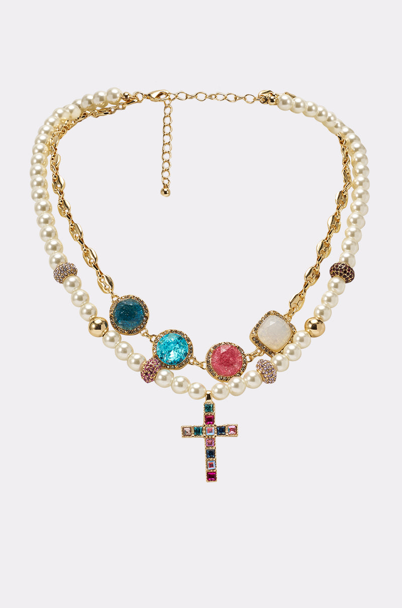 The REGENCY NECKLACE features two strands—one pearl and one twisted gold link—adorned with colorful gemstones and a beaded cross pendant, plus an adjustable clasp. 1