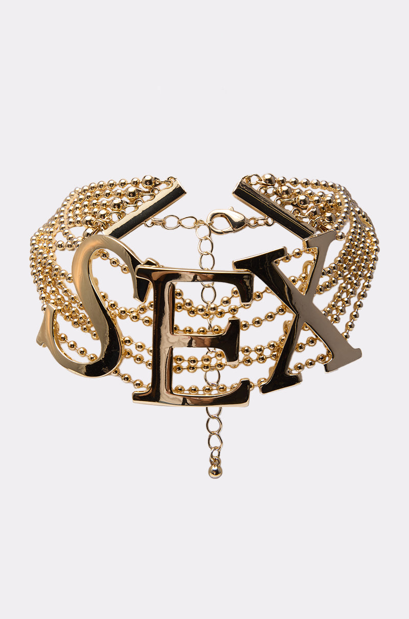A bold gold choker necklace, the LETS DO IT NECKLACE features multiple beaded chains and oversized letter pendants at the center spelling "LETS DO IT"—a striking statement piece for your collection.