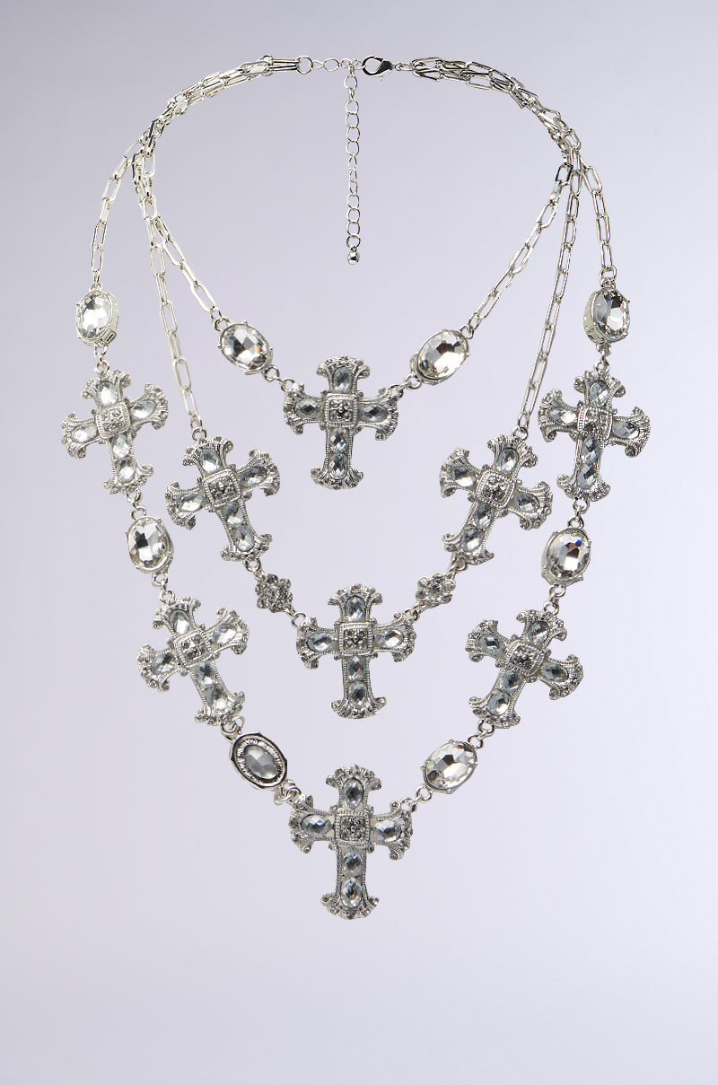 Introducing the SO TRENDY NECKLACE: A triple-layer silver chain adorned with intricate cross charms embellished with rhinestones and oval accents, creating a stunning cascading effect against a plain white background. 3