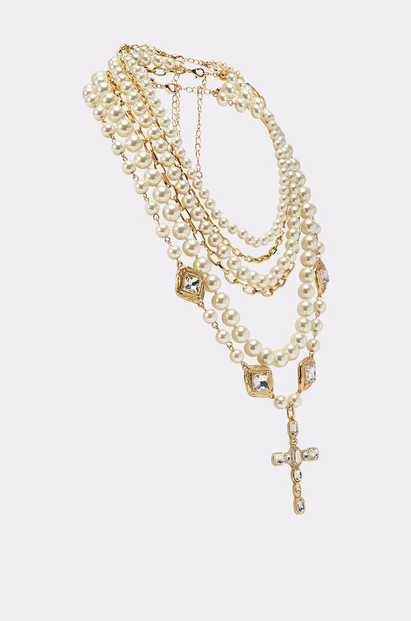 The ITALIAN LOVE NECKLACE SET features layered faux pearls, gold chain accents, square crystal details, and a crystal cross pendant, beautifully showcased against a white background. 2