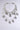 The IN MY CITY NECKLACE features sparkling "NY" rhinestone pendants on layered tiers, elegantly displayed against a plain light gray background.