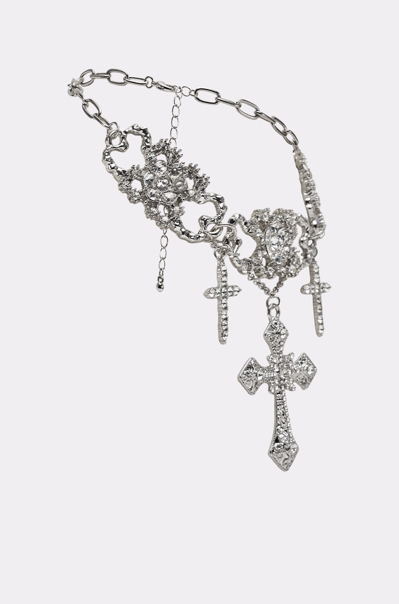 The FOREVER PROTECTED NECKLACE showcases a silver filigree chain with ornate crystal clusters and three rhinestone-adorned cross pendants, displayed on a plain white background. 2