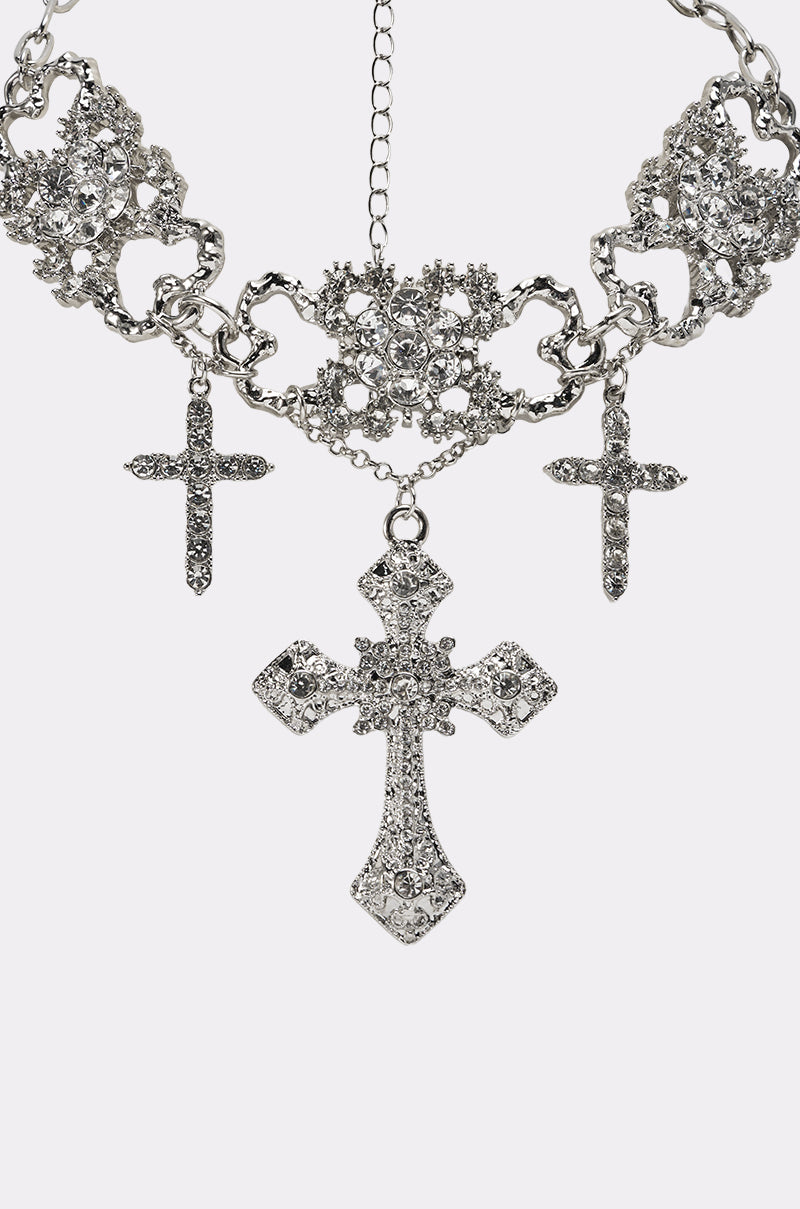 The FOREVER PROTECTED NECKLACE features a silver-tone filigree chain with three sparkling cross pendants, including a detailed centerpiece—an elegant accessory to add timeless charm to any outfit. 3