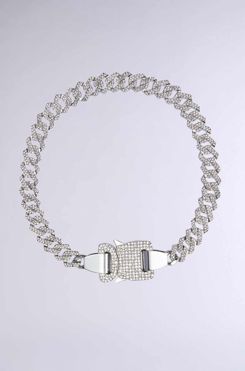 The SAFETY FIRST NECKLACE features large silver Cuban links and a rectangular, diamond-studded clasp, displayed against a plain light gray background.