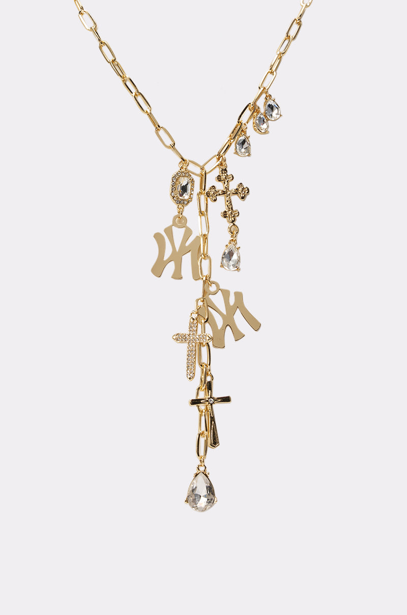 The IN YA CITY NECKLACE features gold-tone charms with crystal teardrops, rhinestone crosses, and gold New York Yankees logos, displayed on a plain white background. 2