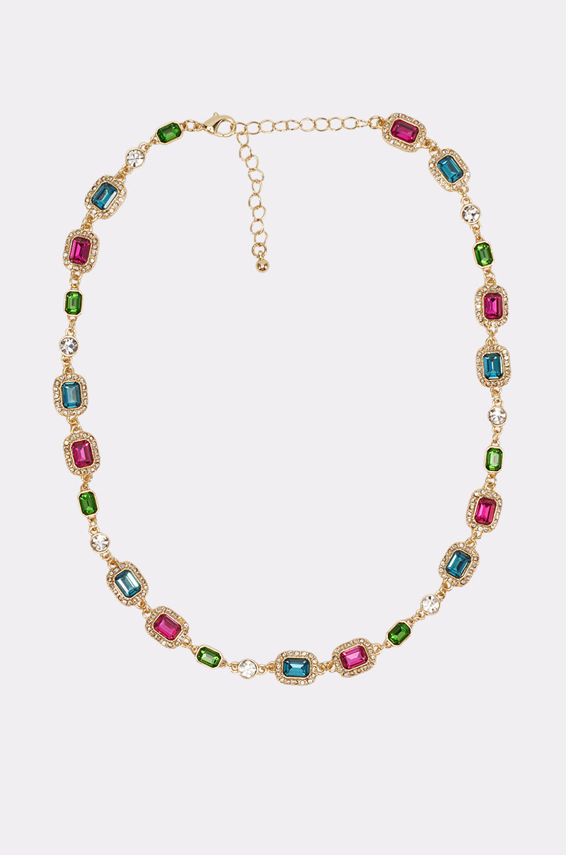 Introducing the COLOR ME RICH NECKLACE: a gold pendant necklace adorned with rectangular multicolor gemstones in pink, blue, and green—each framed by sparkling clear stones. The gemstones are evenly spaced along the chain, making this vibrant piece a stunning accessory for any party or elegant occasion.