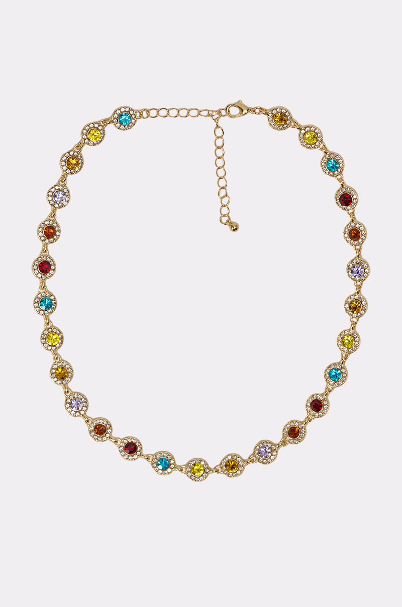The COME CORRECT NECKLACE is a gold-tone metal piece with a wavy design, featuring alternating multicolor faceted stones edged by clear crystals. It has an adjustable chain and clasp for a customizable fit. 4