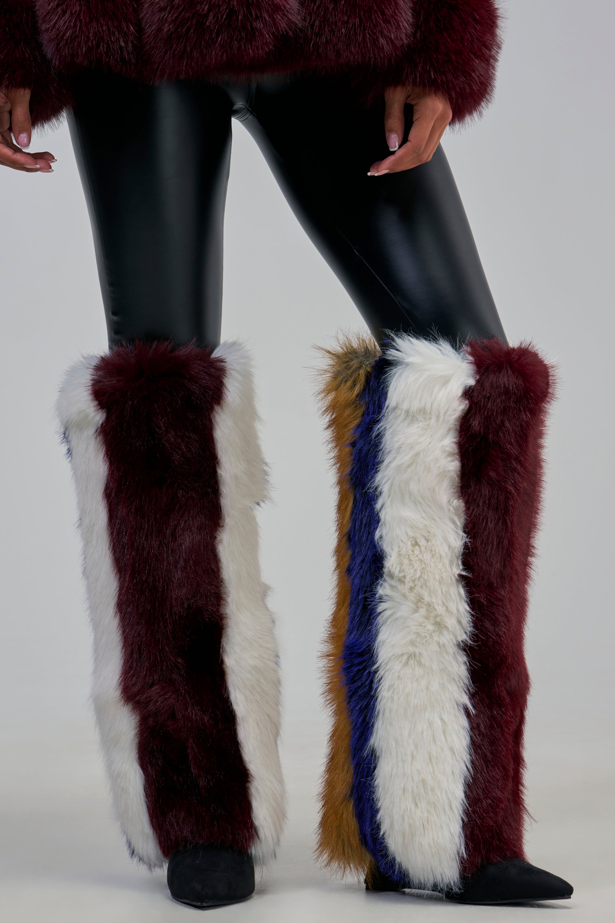 AZALEA WANG SLATE MULTI FUR WEDGE BOOT knee-high boots featuring thick vertical stripes of white, maroon, blue, and brown, worn with black leggings for winter-chic styling.