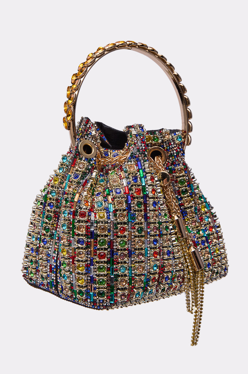 The GEGE BLING PURSE is a small rhinestone bag with a gold chain handle, featuring a grid of colorful gemstones and crystals for a sparkling, luxurious look.