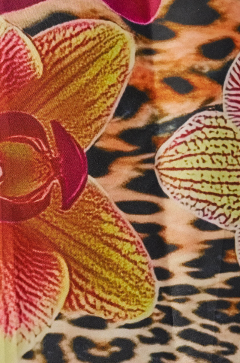 Close-up of the WILDLY FEMME SATIN SCARF, featuring a vivid orchid design with large yellow and pink blooms layered over a bold leopard print background. 4
