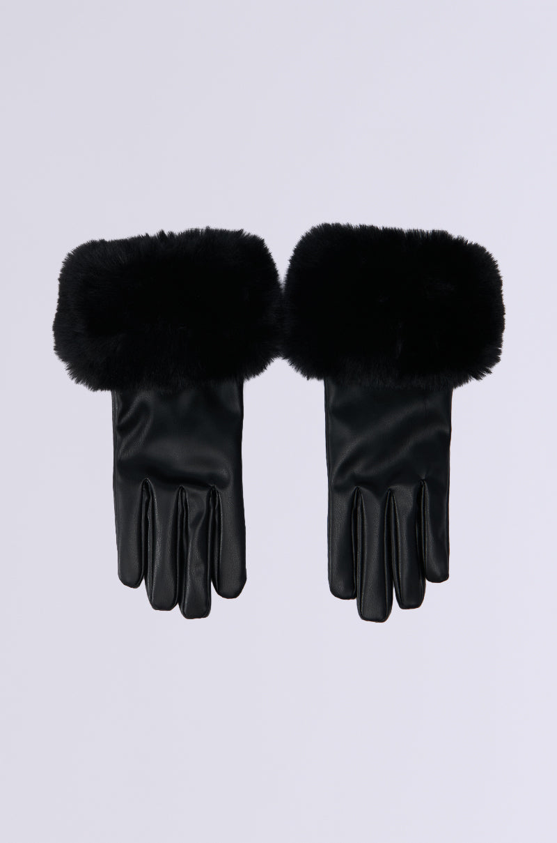 The ALL I WANT IS MONEY FUR GLOVES IN BLACK, featuring black leather with fluffy faux fur cuffs, rest elegantly on a light grey background, seamlessly blending style with functionality.