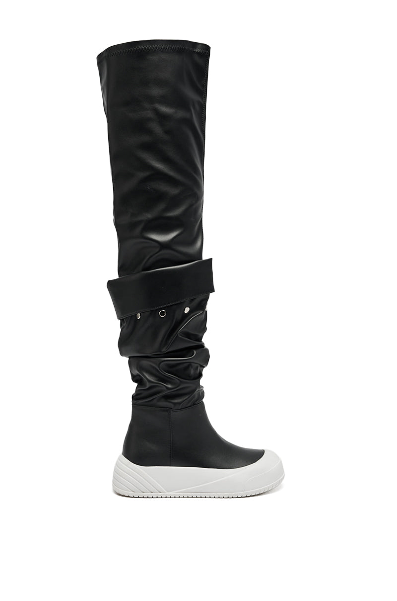 The AZALEA WANG SMARTER BLACK RUCHED PU FLAT BOOT features a slouchy shaft, decorative grommets, and a thick white sneaker-style rubber sole, shown here solo on a white background.