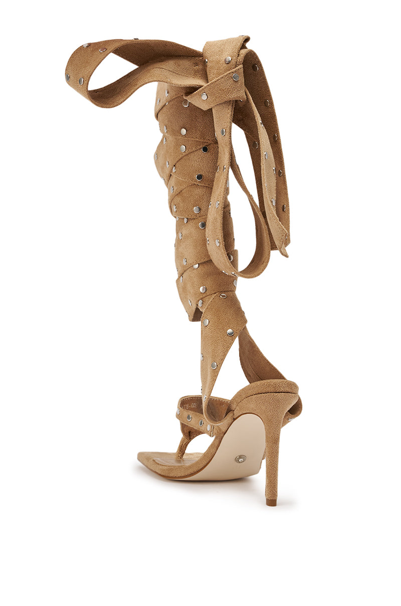 The AZALEA WANG SODALITE NUDE FAUX SUEDE LACE UP SANDAL features a tan faux suede finish, open toe, studded details, and long wraparound straps that tie up the leg for a chic statement look. 6