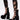 A person wears black lace-up leggings with bold cutouts and bows, paired with AZALEA WANG SPREENE FRILL LACE PUMPS IN BLACK featuring lace ruffles, creating a striking gothic chic look against a plain white background.