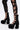 A person wears black lace-up leggings with bold cutouts and bows, paired with AZALEA WANG SPREENE FRILL LACE PUMPS IN BLACK featuring lace ruffles, creating a striking gothic chic look against a plain white background.