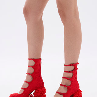 Model wears the AZALEA WANG SPREENE RED CHUNKY PUMP—bold, bright red faux leather lace platform heels with four buckled straps, ruffled toe details, and chunky heels—shown against a plain white background.