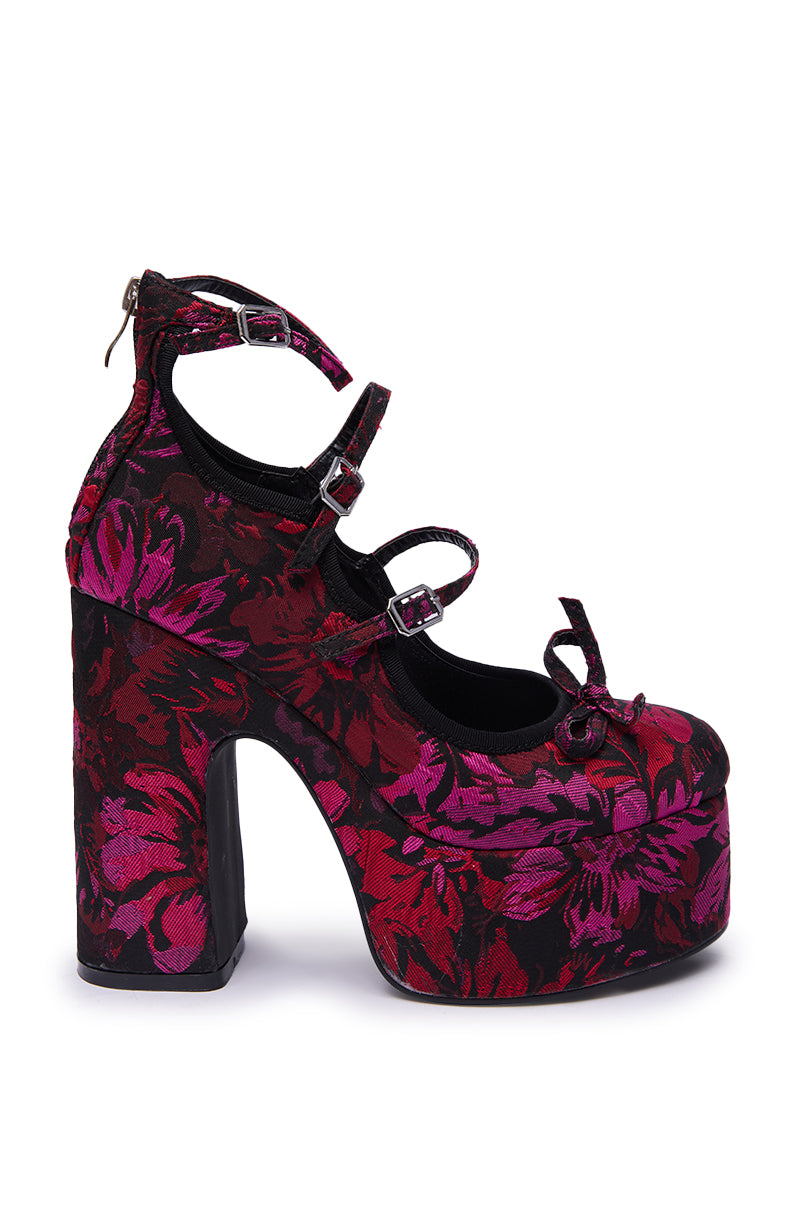 The AZALEA WANG SPROUT Red Multi Floral Brocade Mary Jane Platform Pump features a chunky heel, three ankle straps, a bow on the toe, and a bold red, pink, and black floral brocade pattern.