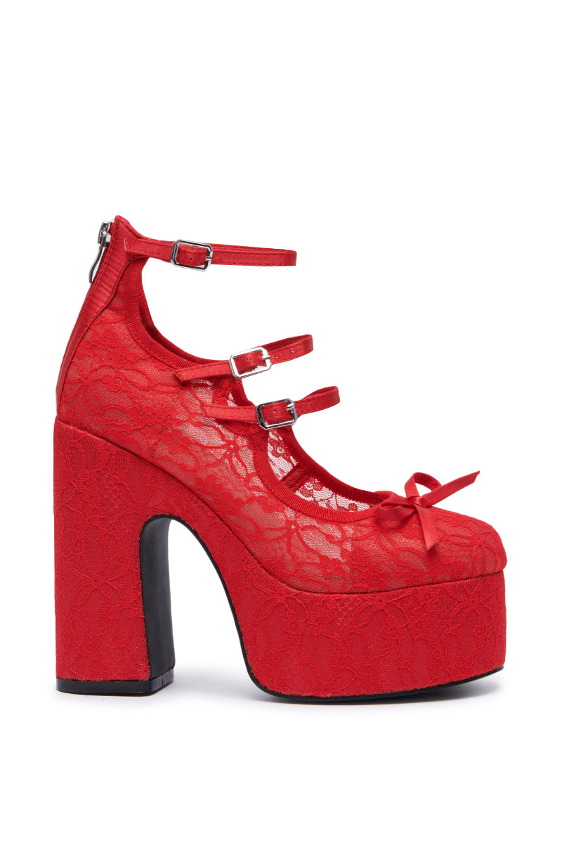 The AZALEA WANG SPROUT RED PUMP is a striking platform shoe featuring a chunky high heel and a lace overlay. It boasts three adjustable straps with metal buckles, a small decorative bow on the front, a closed toe design, and a convenient zipper at the back.
