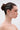 A woman with dark hair in a bun wears NOT SORRY HAIR GEMS that spell “NOT SORRY” on her head. She stands in profile against a plain, light background with a neutral expression.