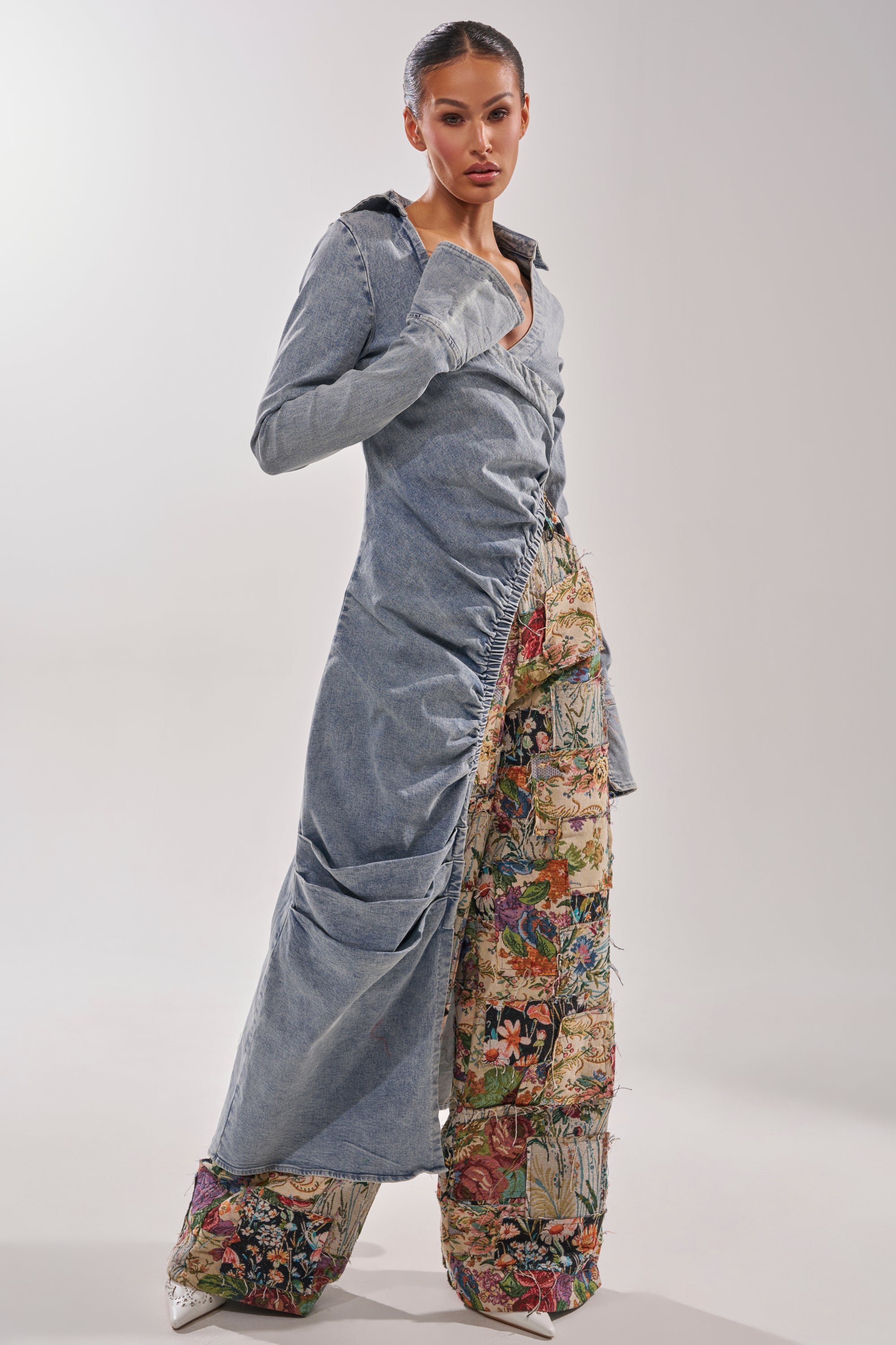 A woman poses in the GET MY CLOSE UP EMBELLISHED BUTTON DOWN SHIRT, styled with wide, quilted pants that feature a colorful, vintage tapestry pattern. 2
