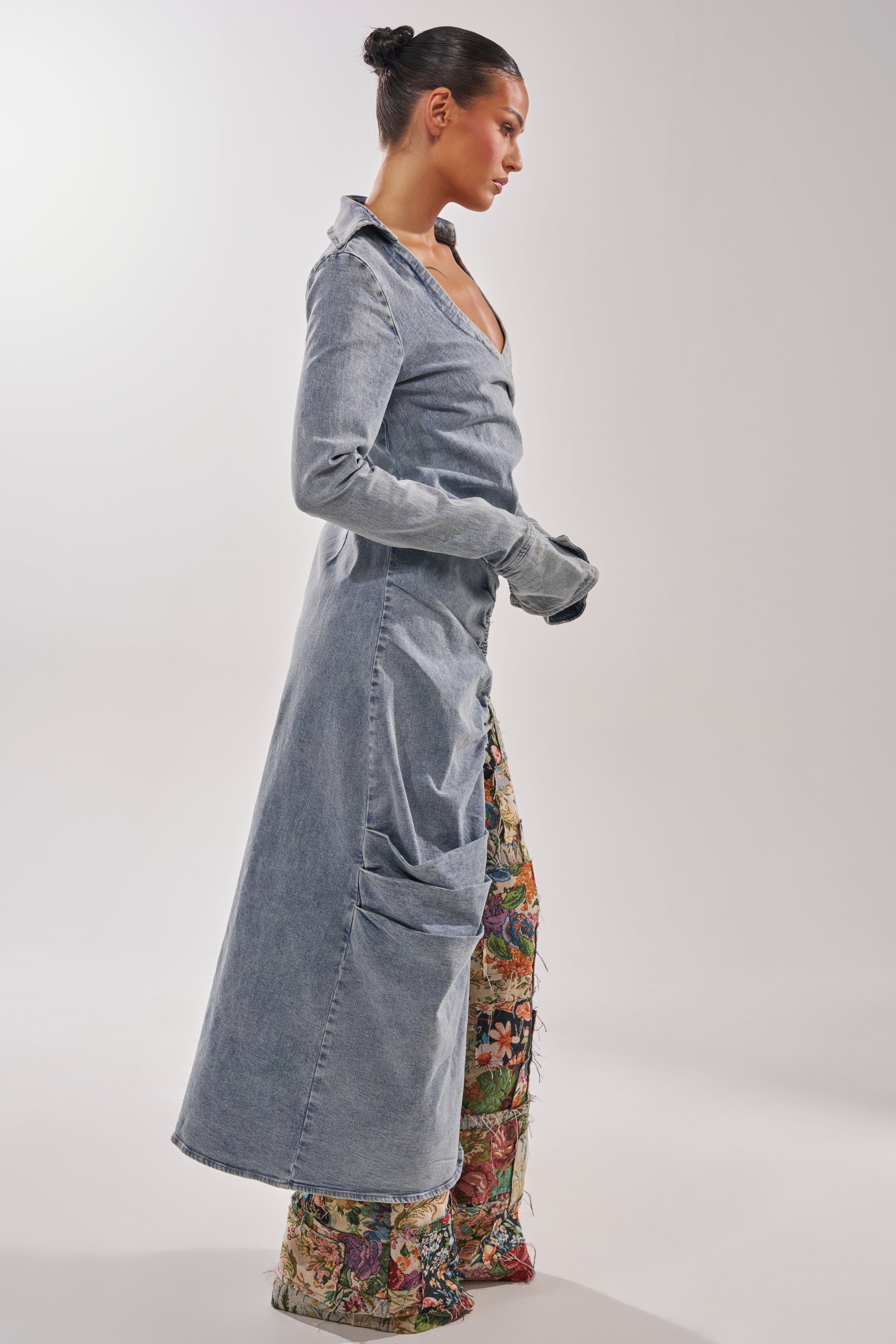 A woman with a sleek bun stands sideways against a plain, light background, wearing the GET MY CLOSE UP EMBELLISHED BUTTON DOWN SHIRT styled over wide-leg patterned pants and matching gloves. 3