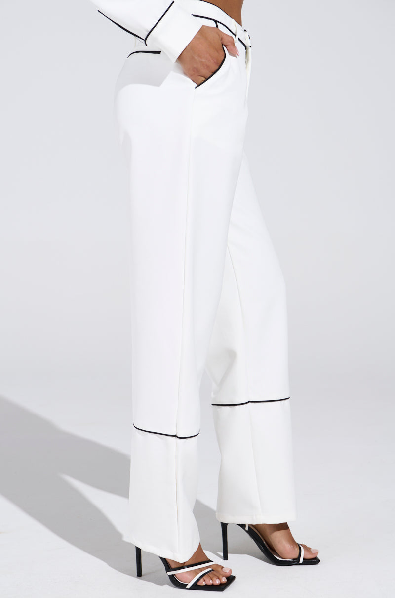 The image shows a person in LISA CUFFED WOVEN PANT with a straight leg silhouette and black contrast piped detailing, paired with a matching jacket and open-toed high heels, all set against a plain white background.