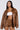 A person with long hair wears the BIRDIE OVERSIZED BOMBER and matching shorts. A white crop top is underneath, while the jacket's quilted interior adds texture. The background is plain gray.