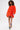 A woman with curly hair stands out in the IN THE NAME OF FASHION RUFFLE MINI DRESS, styled with colorful cartoon-printed boots, against a plain white background.