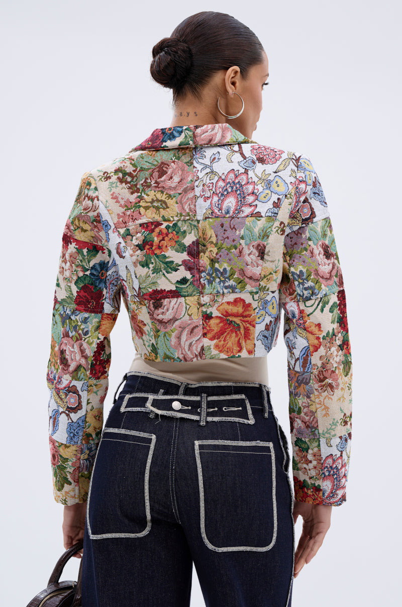A woman wearing the TAKE A HINT PATCHWORK BLAZER, a vintage-inspired piece featuring delicate botanical and floral patterns.