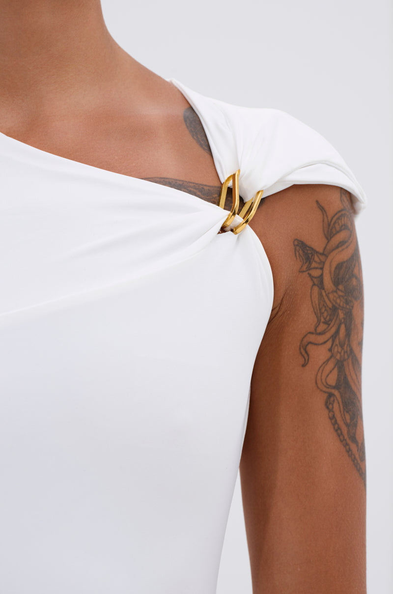 A close-up of a person wearing the IZZY SEAMLESS BODYSUIT with gold links at the straps, crafted from body-contouring fabric, showcasing their detailed shoulder and upper arm tattoo against a plain, light background. 9
