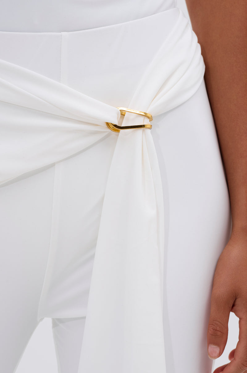 A close-up of a person wearing the white IZZY SEAMLESS LEGGING, crafted from body-contouring fabric, styled with a matching white belt featuring a gold rectangular buckle, and one hand relaxed by their side. 6