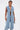 Wearing the DOWN TO IT SPLIT DENIM VEST over a white bralette and light-wash denim pants, paired with silver jewelry and a silver purse, this streetwear look stands out against a plain white background.