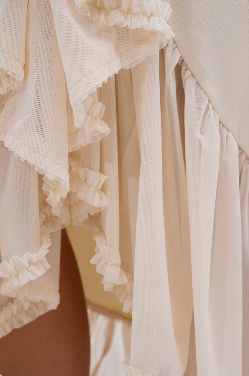Close-up of the MELISSA MESH RUCHED SKIRT, showcasing cream-colored, sheer layers with ruffled edges that drape softly for a delicate, airy effect. 6